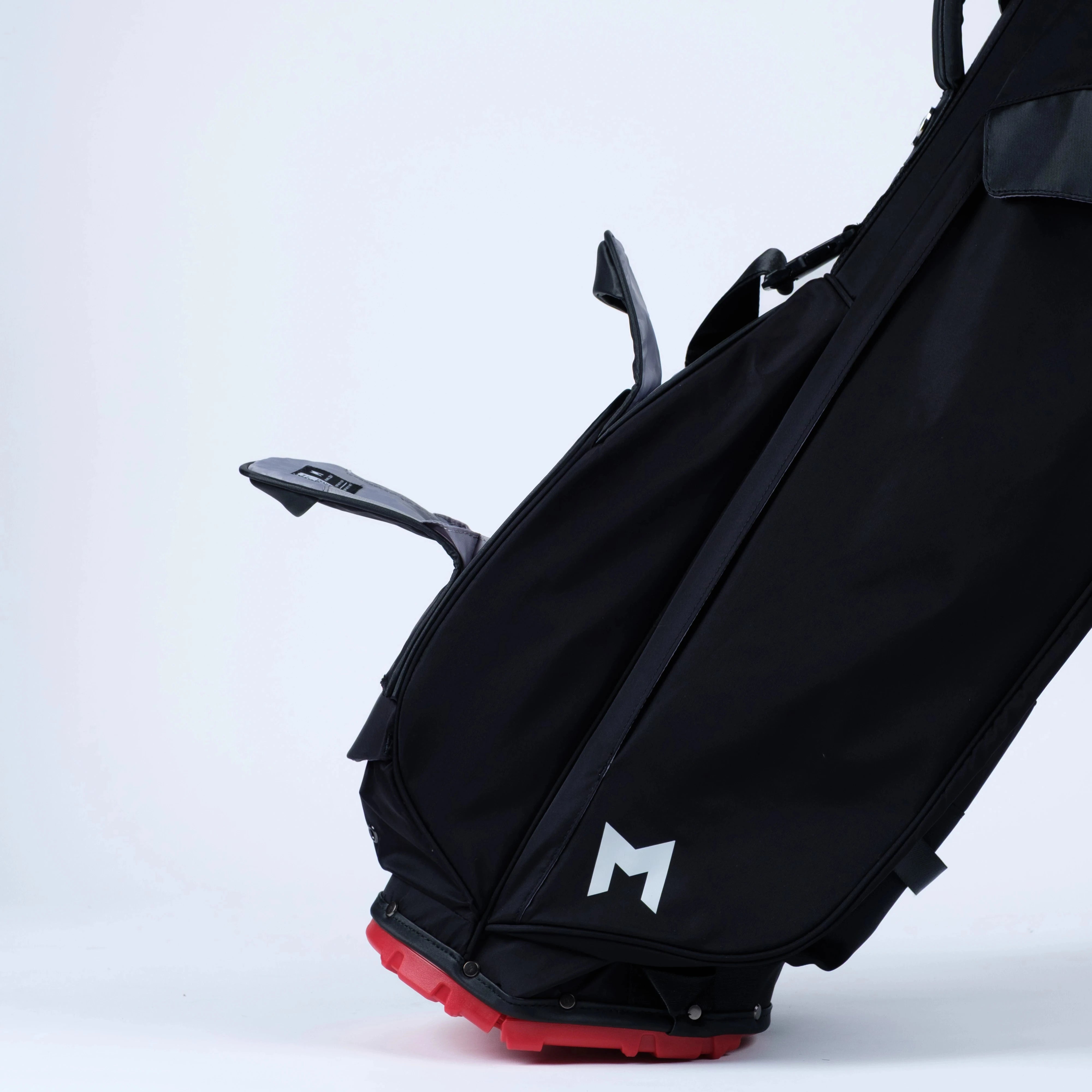 Black golf bag with magnetic pockets and a red bottom on a white background