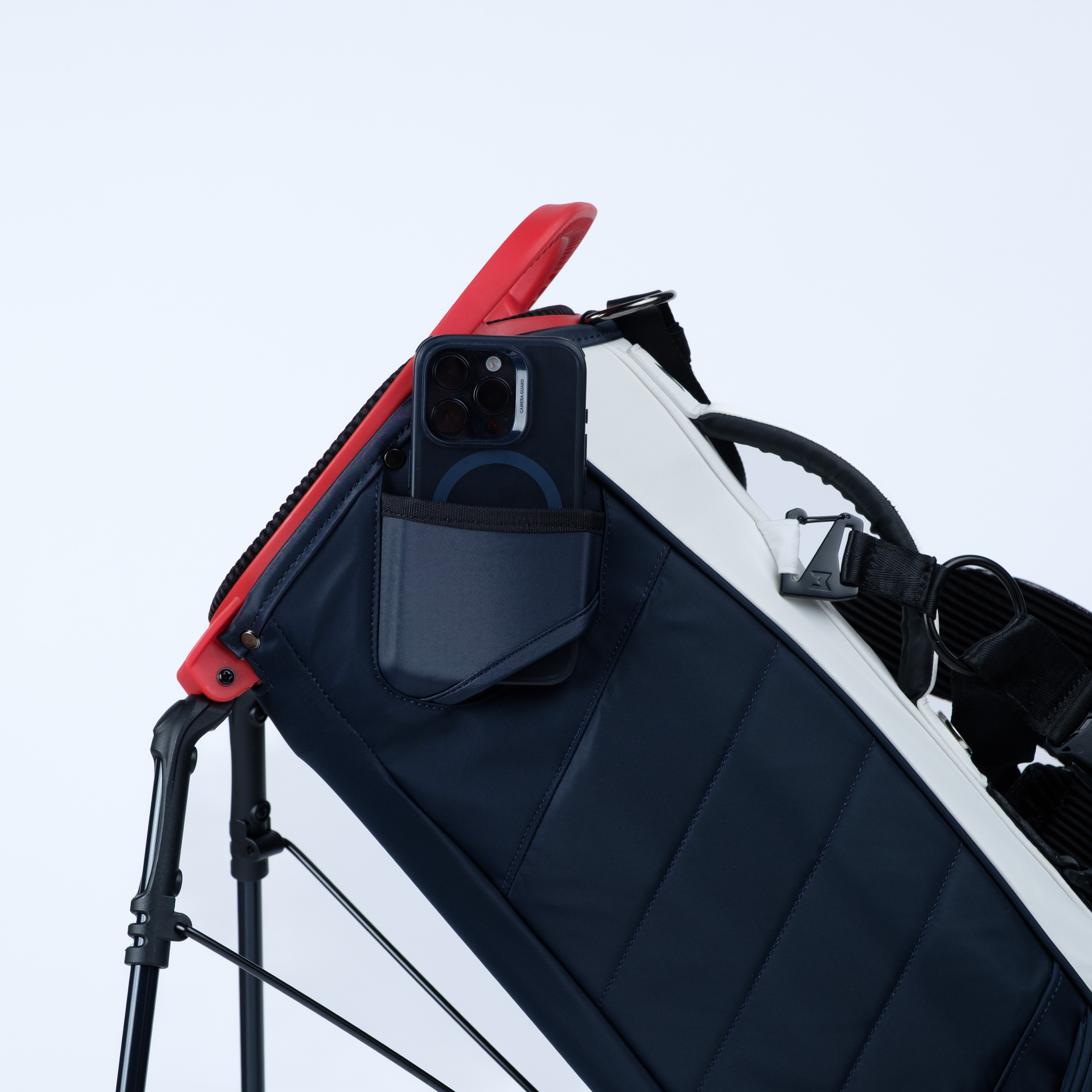 Close-up of a golf bag with a filming pocket for phones on a light background