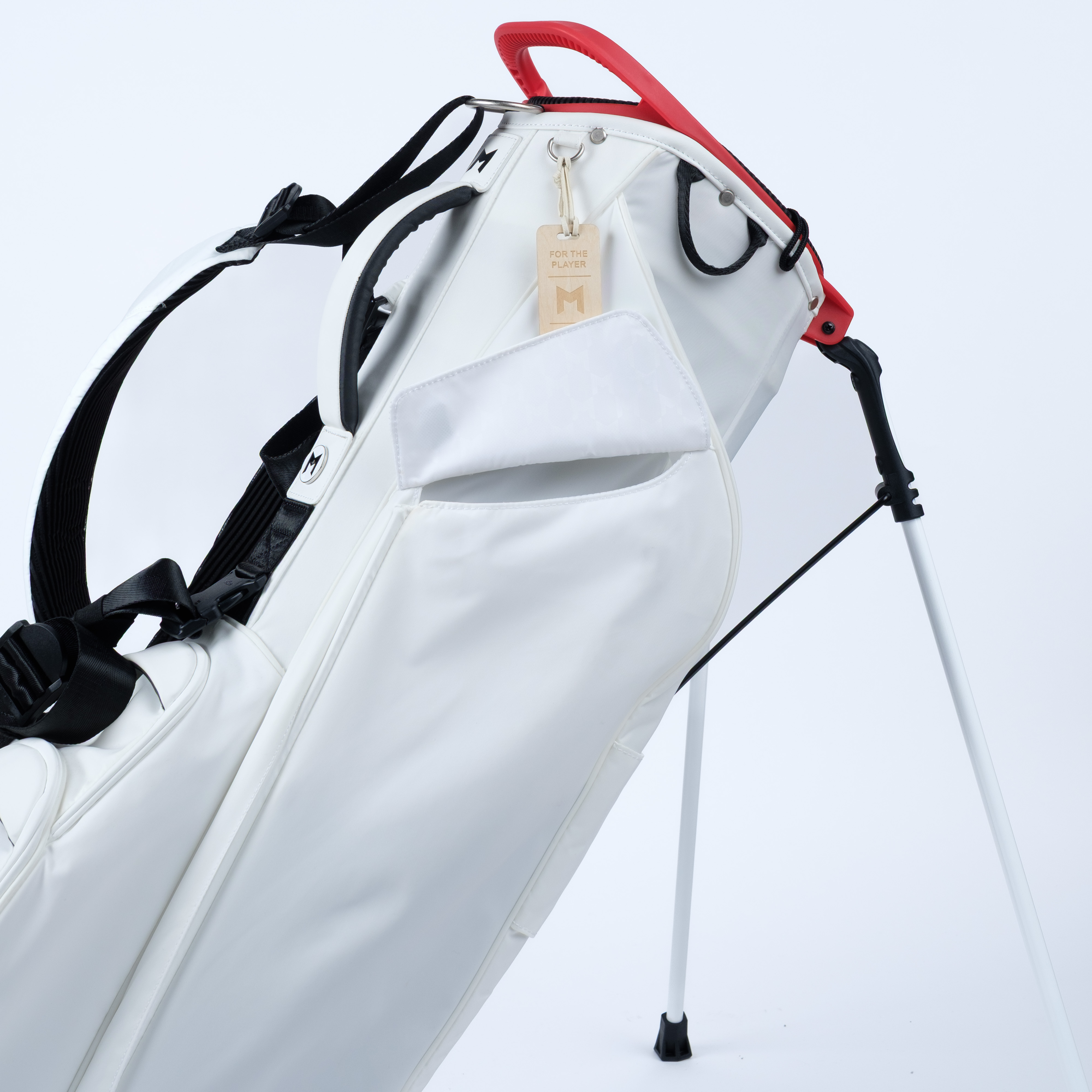 White golf bag with magnetic pockets on a red accents on a light blue background
