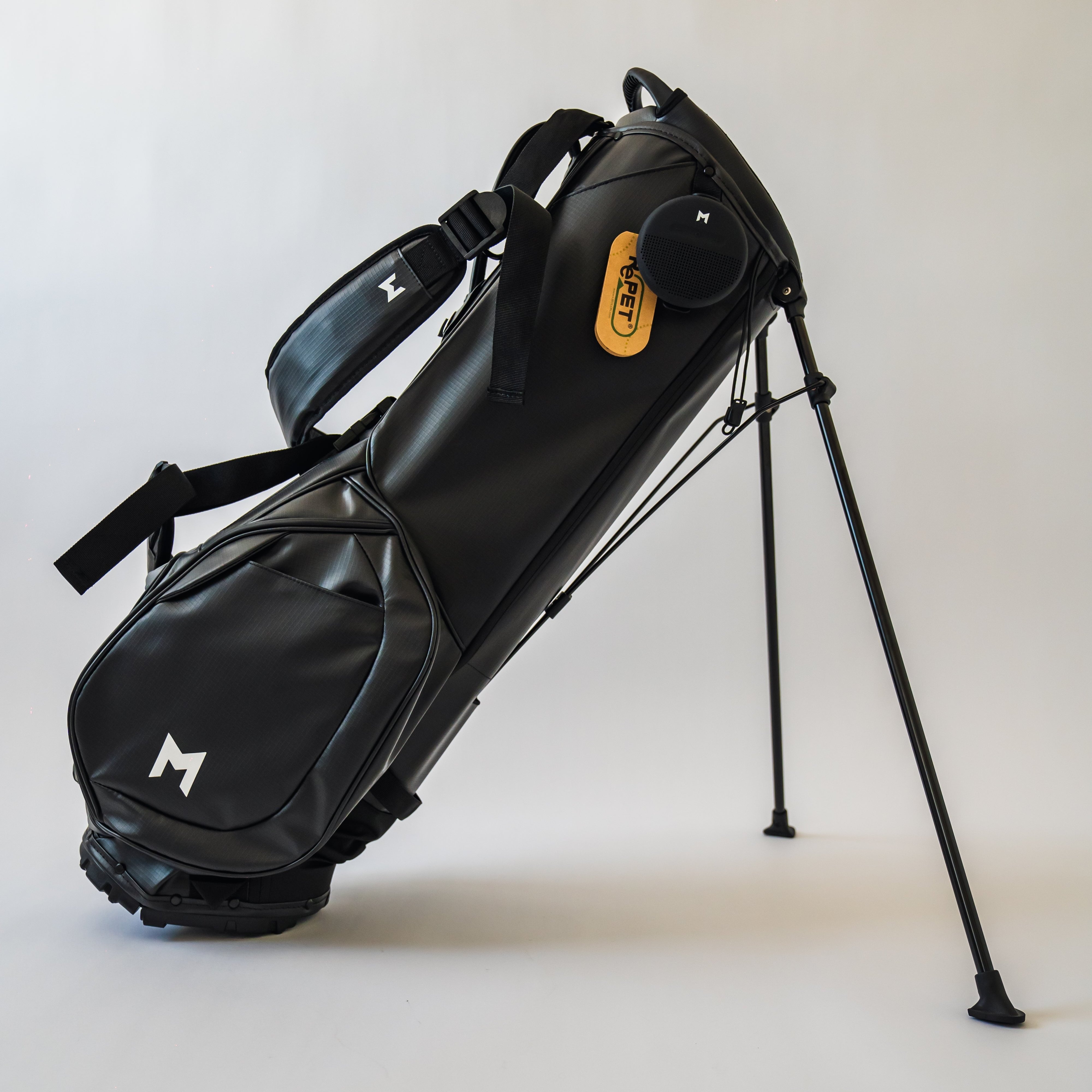 Right panel view of MNML GOLF's black MR1, customizable golf bag with single to double strap-mechanism, magnetic pockets, and bluetooth speaker attached.