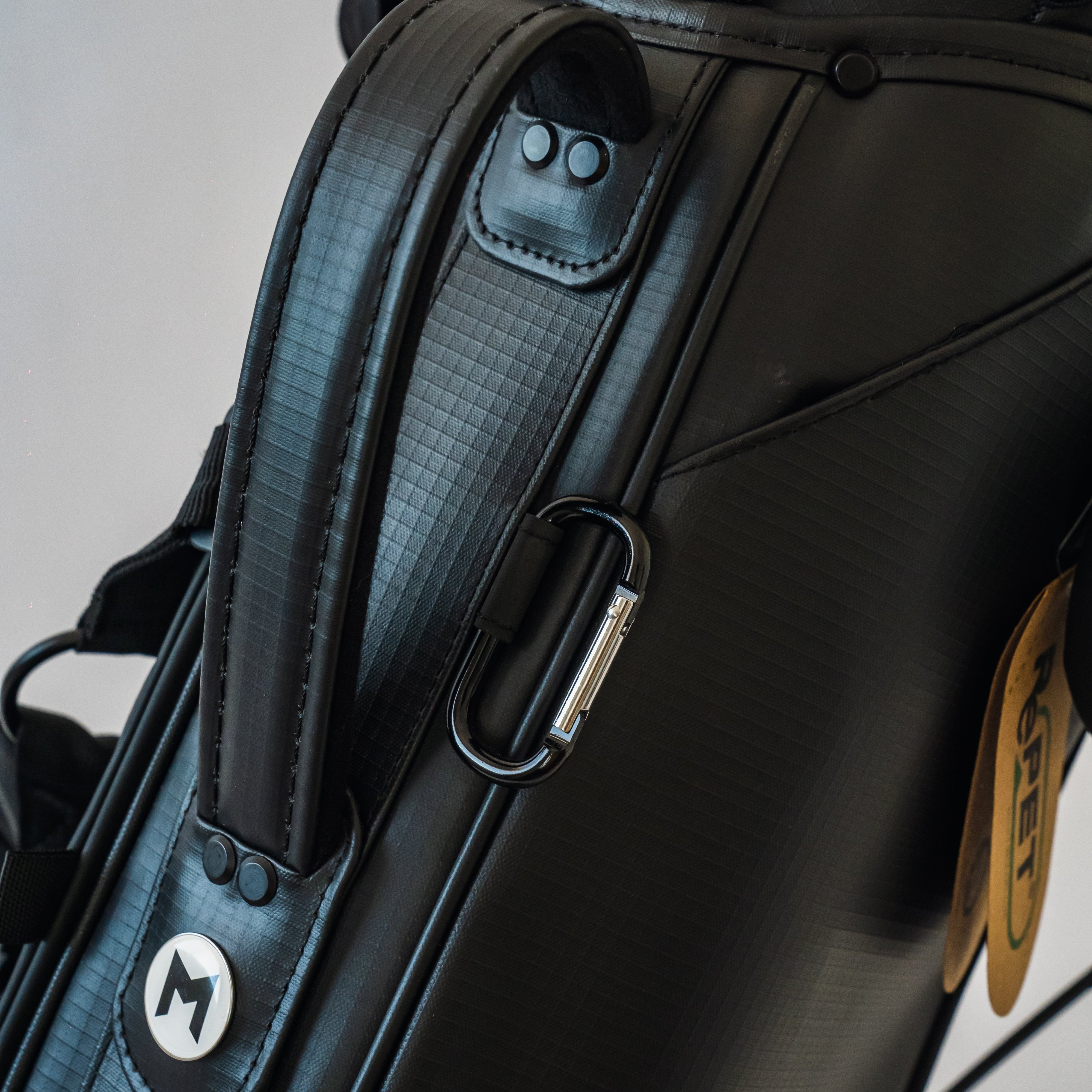 The black MR1 custom golf bag's top handle with a magnetic ball marker below.