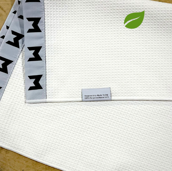 The MNML GOLF eco towel is available in black or white with the minimal branding and a waffle style fabrice.