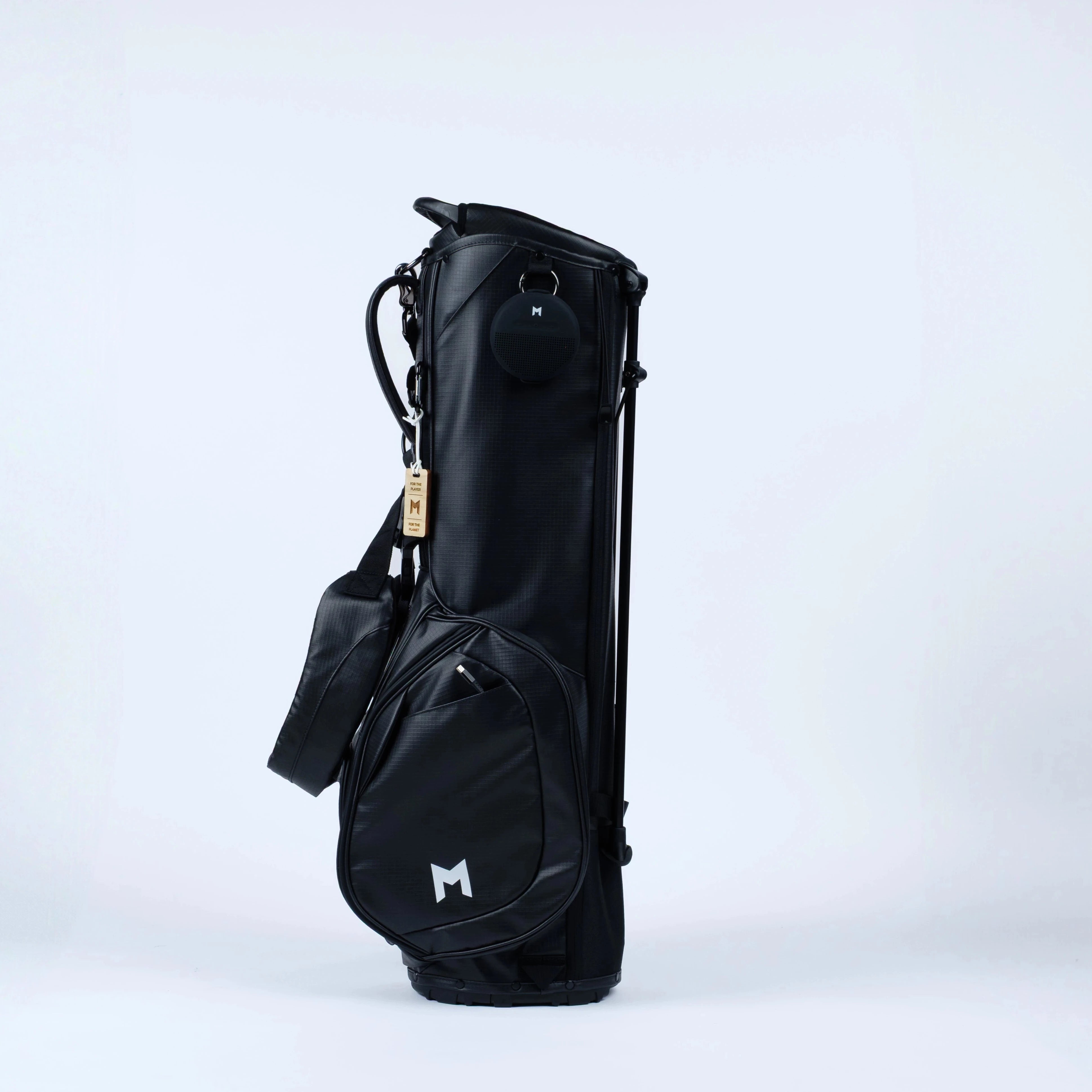 Black golf bag on stand with Bluetooth speaker