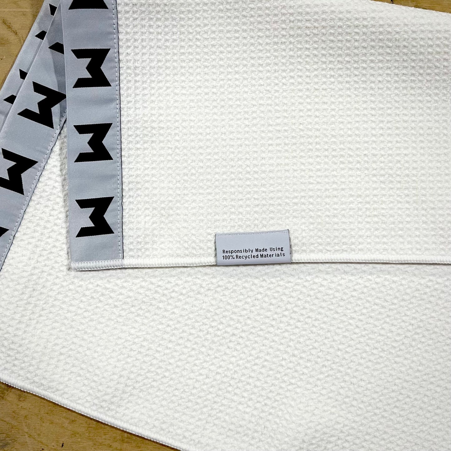 MNML GOLF white, sustainable waffle towel with grey and black logo detailing. 