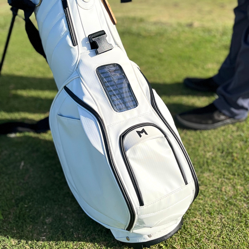 This is MNML GOLF's MR1 sustainable golf bag, in white, featuring our magnetic ball pocket closure and solar power bank.