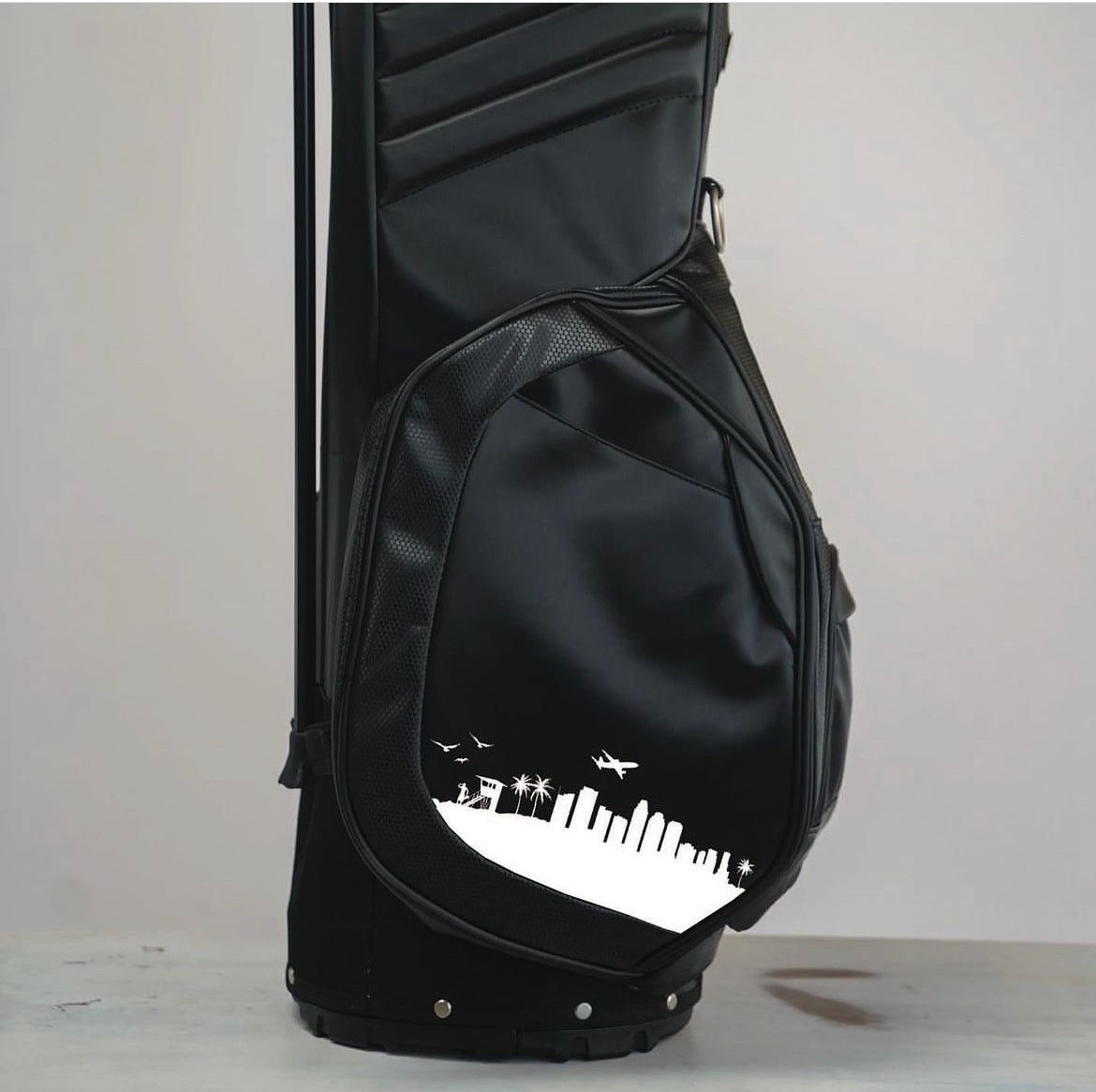 This is MNML GOLF's LA skyline golf bag, in black, with a hand painted silhouette of Los Angeles.