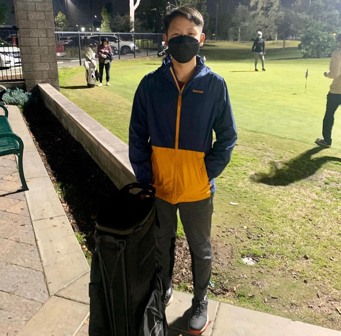 Junior golfer with a black golf bag donated by a MNML GOLF customer.