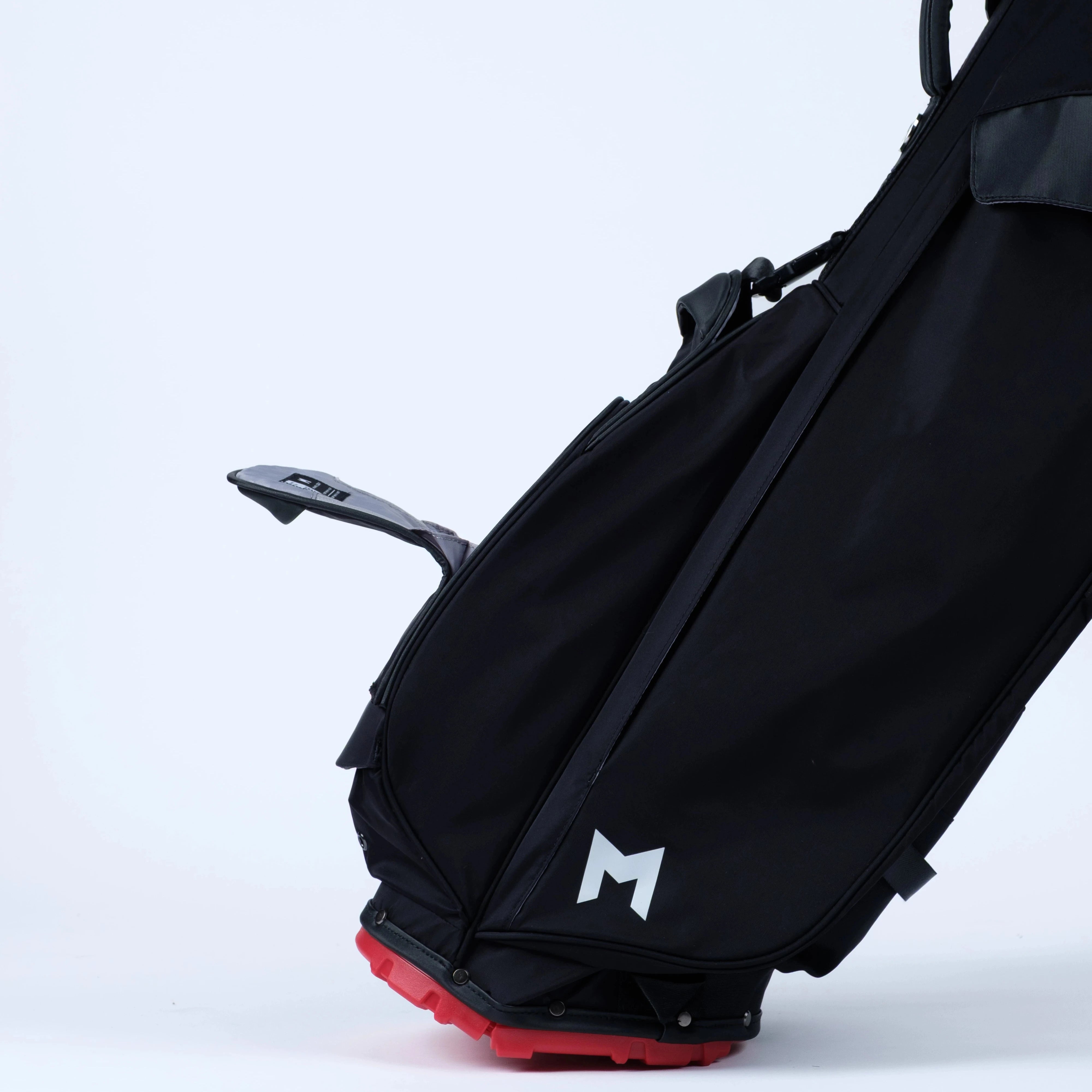Black golf bag with magnetic pockets on a red bottom on a white background