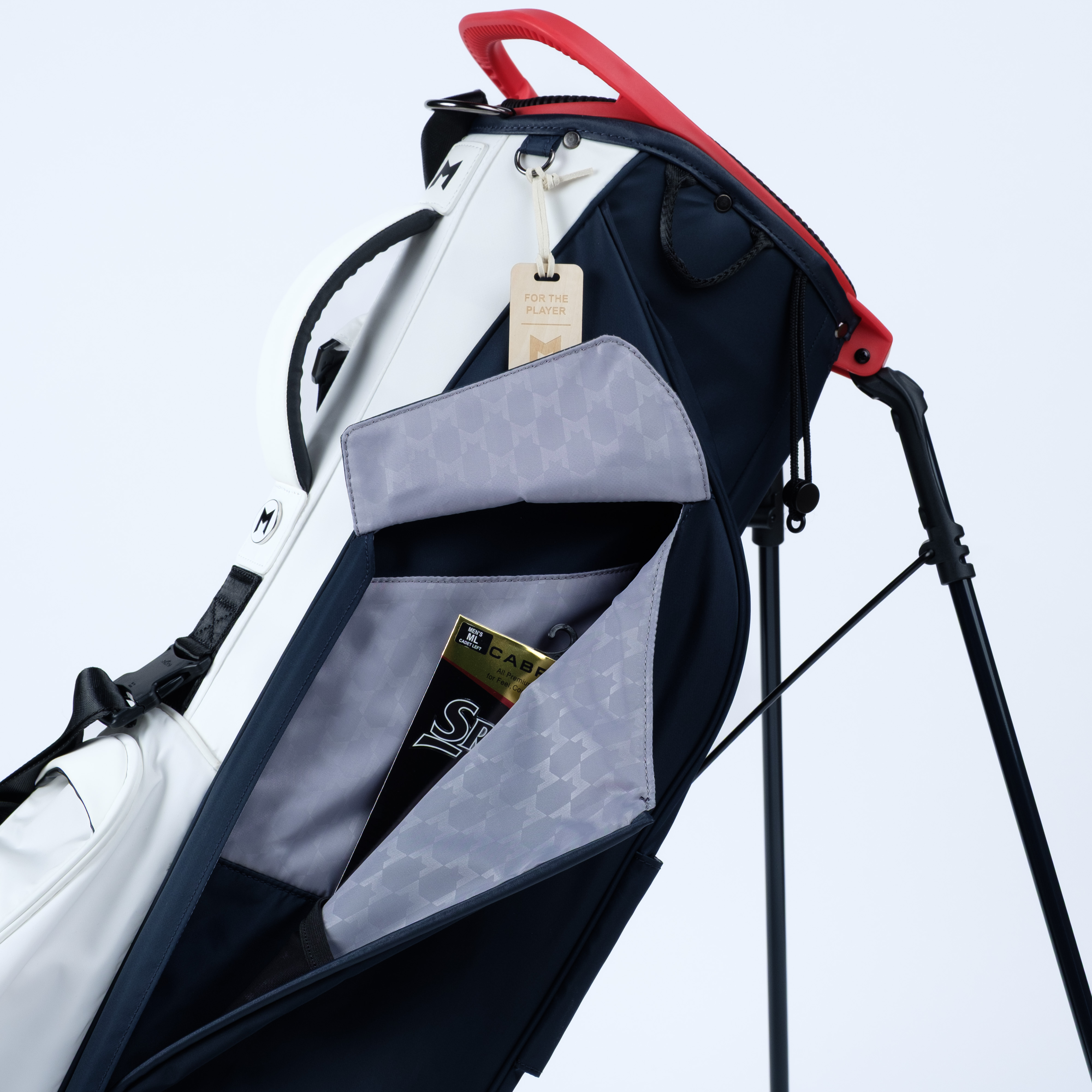 Navy and white golf bag featuring full length magnetic storage pocket for gloves and golf gear