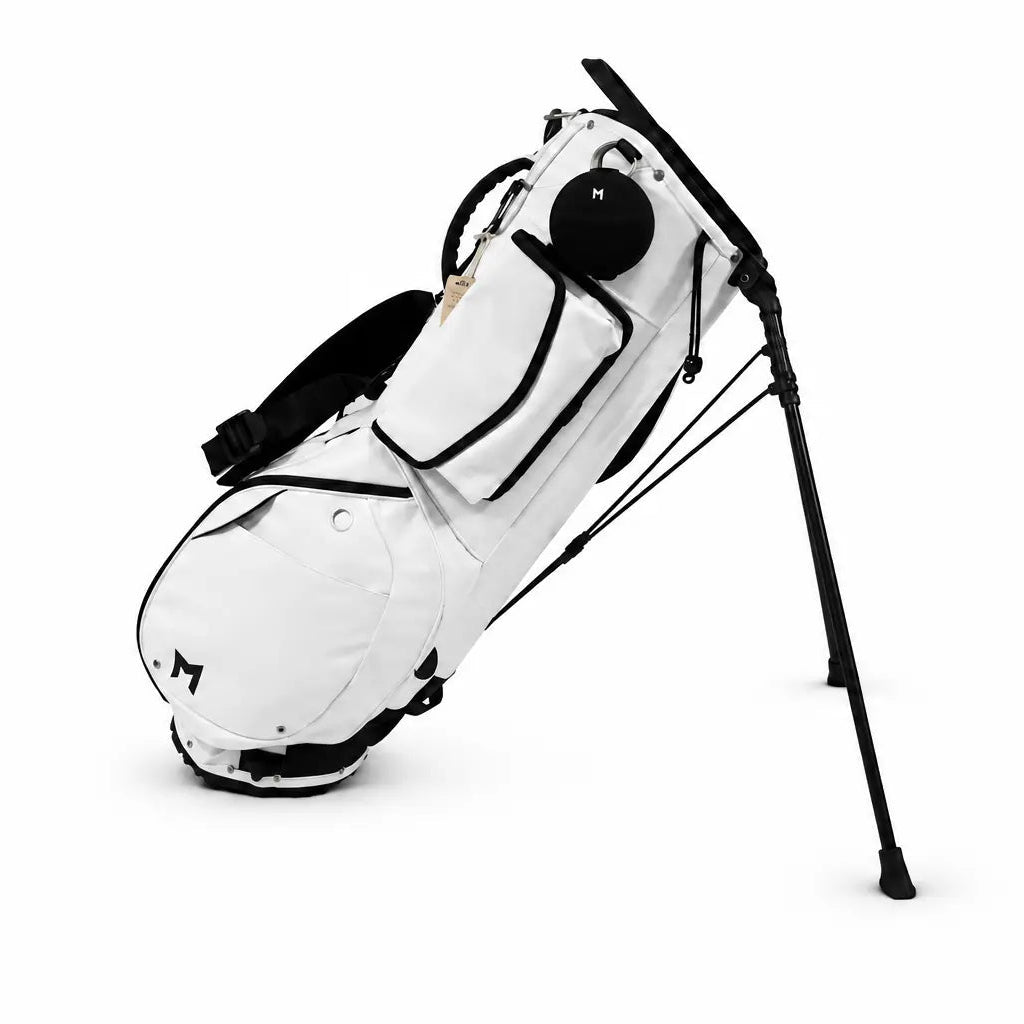 A white stand golf bag with black straps, magnetic pockets, and support legs, shown on a clean white background.