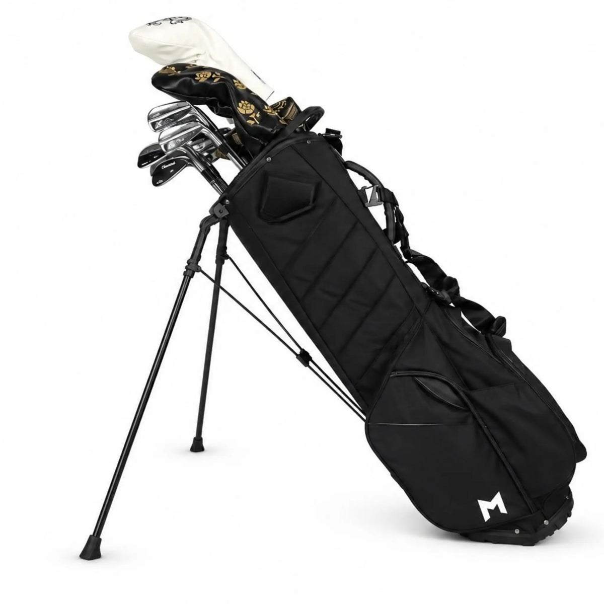 A black stand golf bag with multiple golf clubs inserted, photographed on a clean white background. The bag has a white stylized 'M' logo near the bottom right corner.