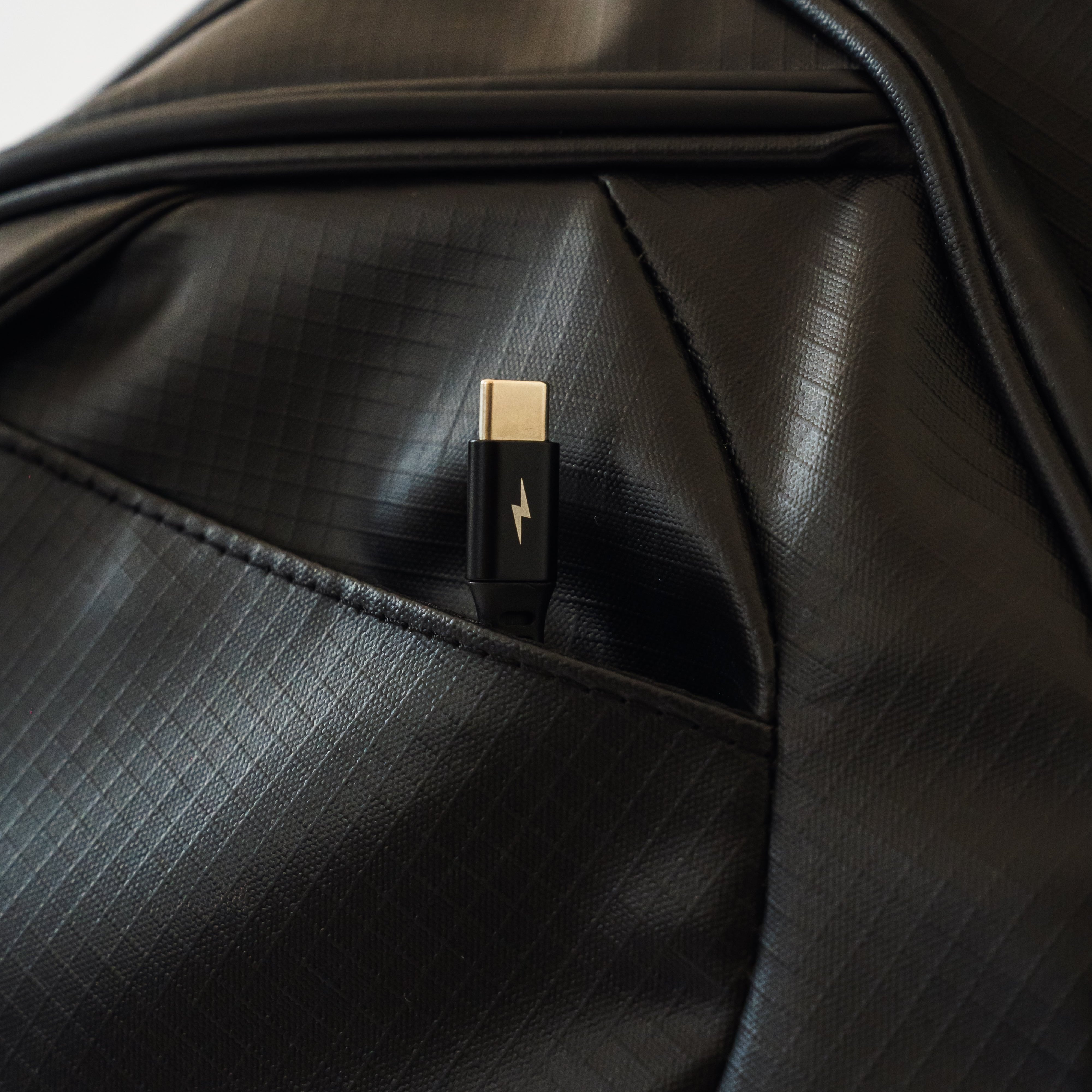 The black MR1 custom golf bag's lightning phone charger tucked away in the magnetic closure pocket.