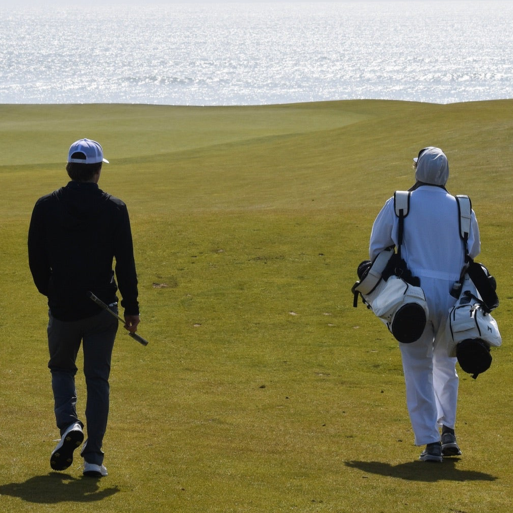 MNML GOLF team member, Campbell and caddy, walking down the fairway at Chamber's Bay golf course.