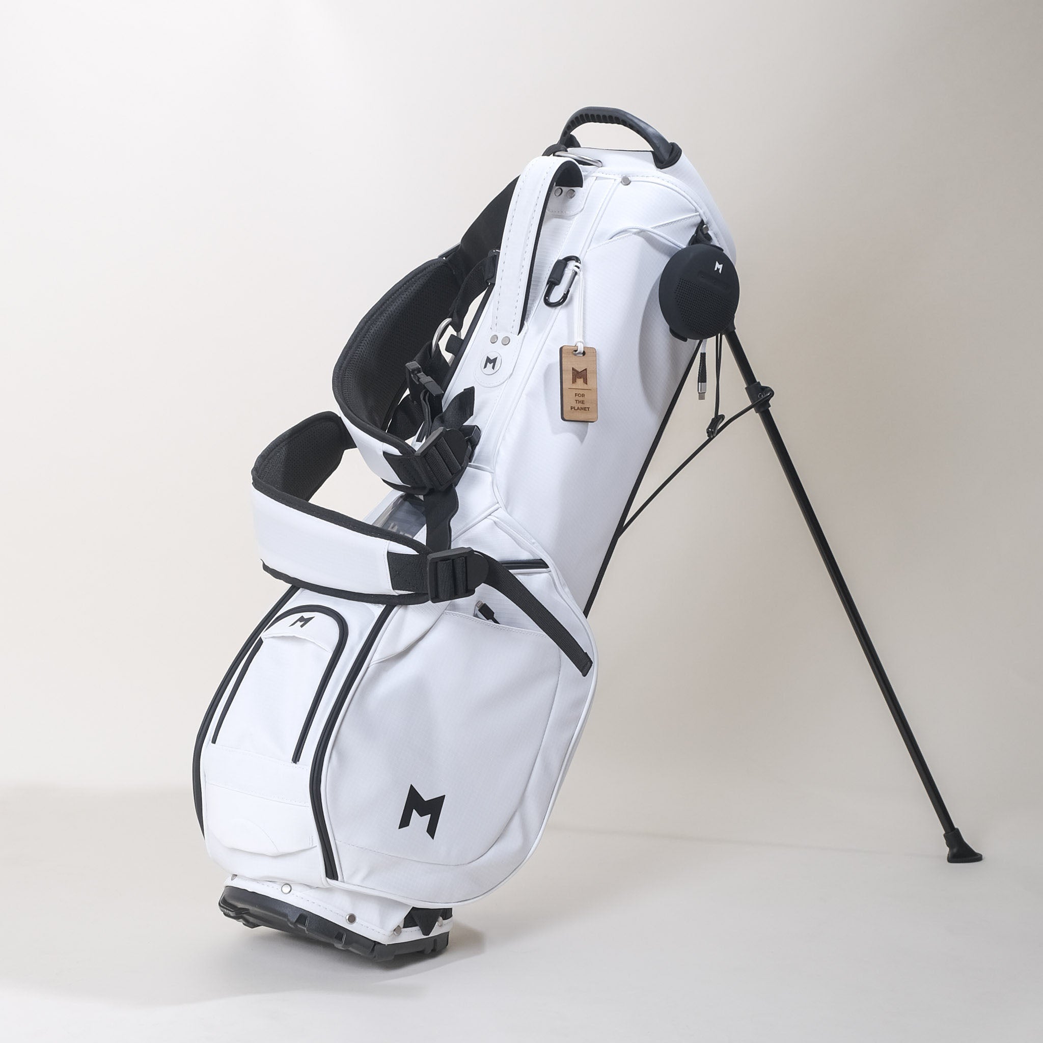 MNML GOLF's white MR1 custom golf bag standing and displaying single to double golf bag strap mechanism, and all magnetic pockets.