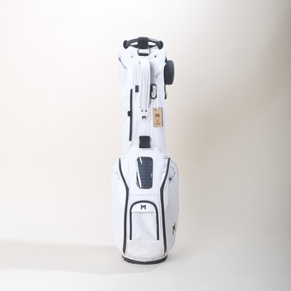White 100% GRS Certified recycled material golf bag. MNML GOLF "M" logo on side pocket. All magnetic pockets, and cell phone pocket for filming, comes with a MNML GOLF ball marker. Free standing bag with legs and straps. Thermal Pocket (holds up to 5, 16oz bottles or 6 12oz cans), and 5-Way Divider (two full length). Add on's include a solar panel cell phone charger, for Android or IPhone; waterproof bluetooth speaker with 8hr battery life available for purchase. 