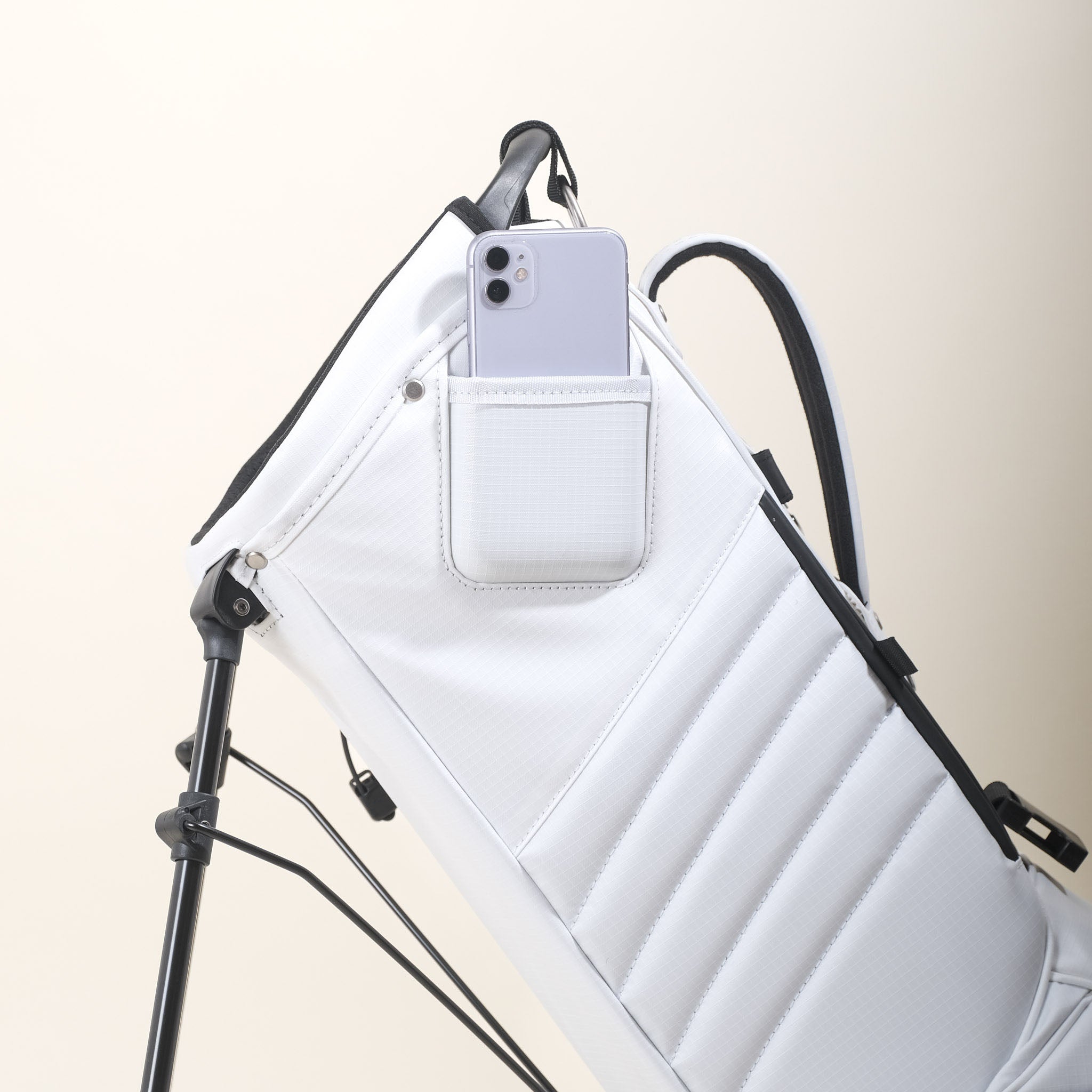 Up close of the white MR1 custom golf bag's phone filming pocket with a white iPhone.