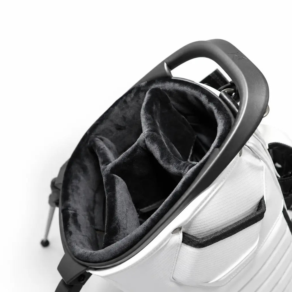 Close-up of a white and black golf bag showing the top opening with a black plush lining and handle, on a white background.